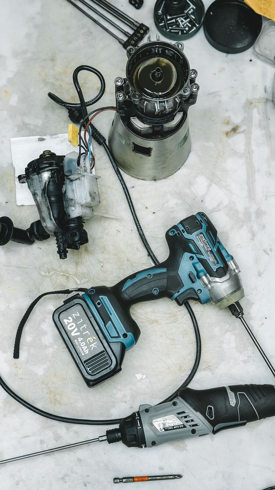 Blender motor base opened on a workbench next to cordless screwdrivers